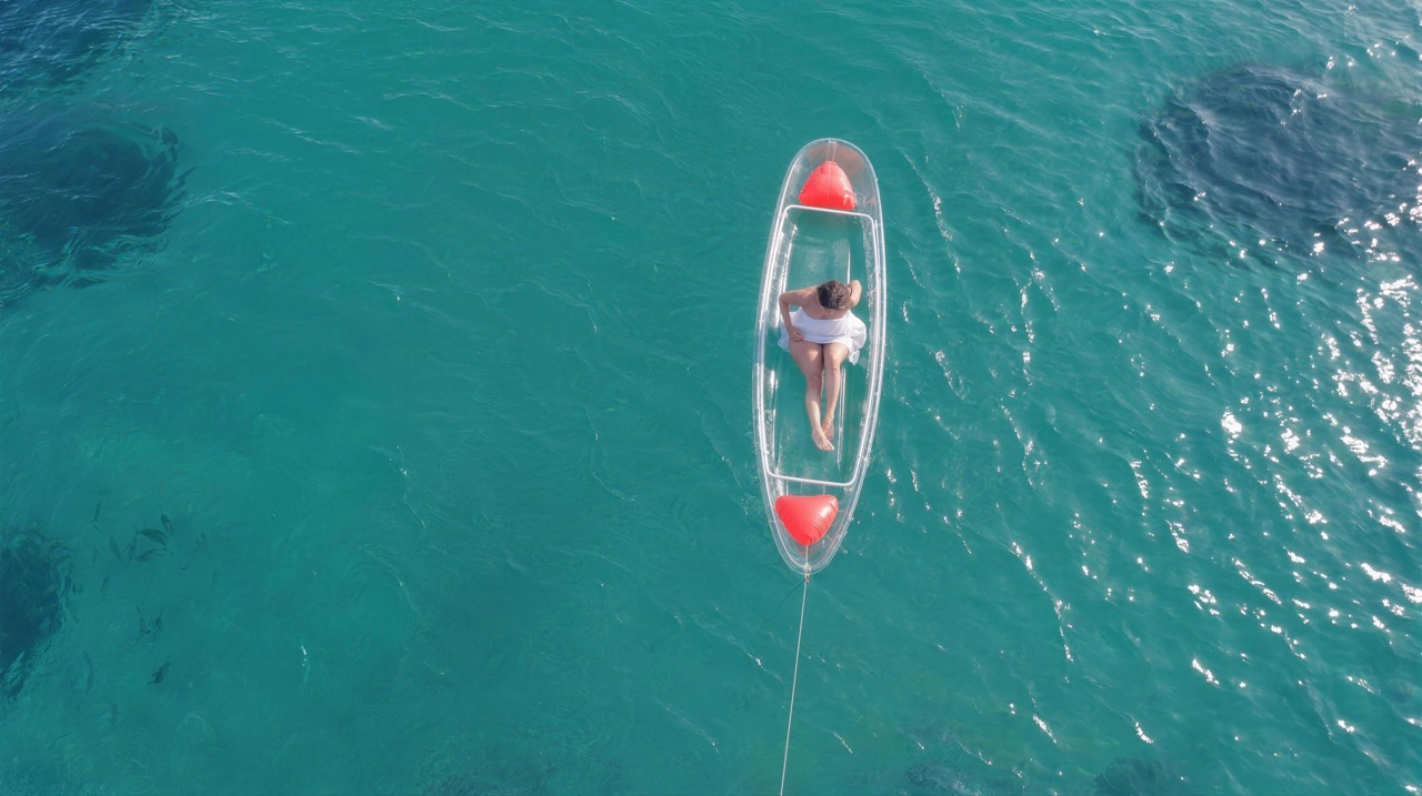 Vue drone d’un kayak transparent sur l’eau turquoise de Ouakam, Dakar